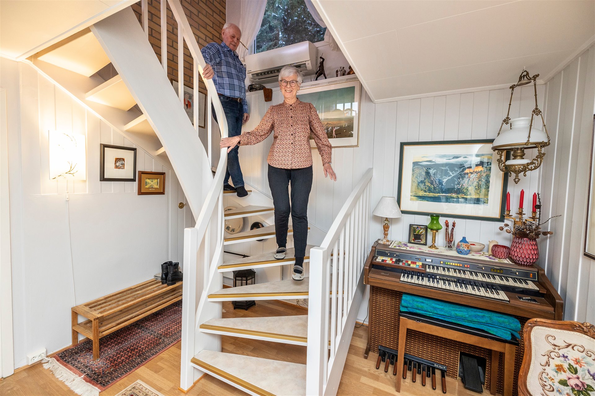 To eldre mennesker på vei ned trapp. 